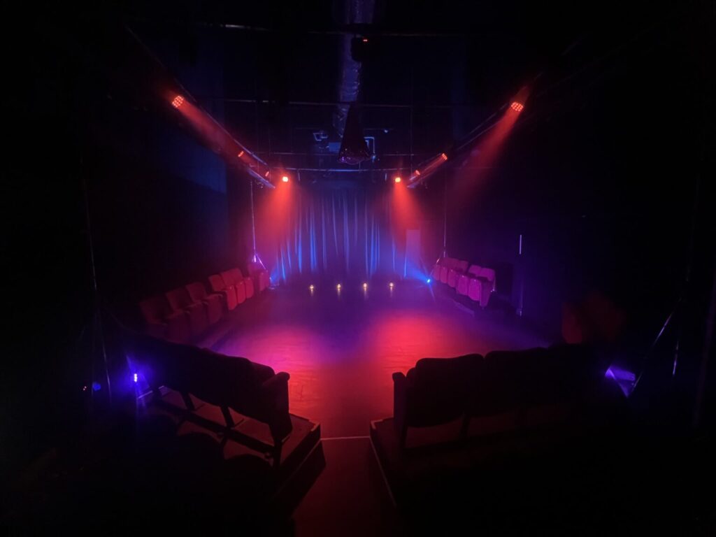 Theatre Space for Salford’s Next Generation Perfornace area lit in orange and blue