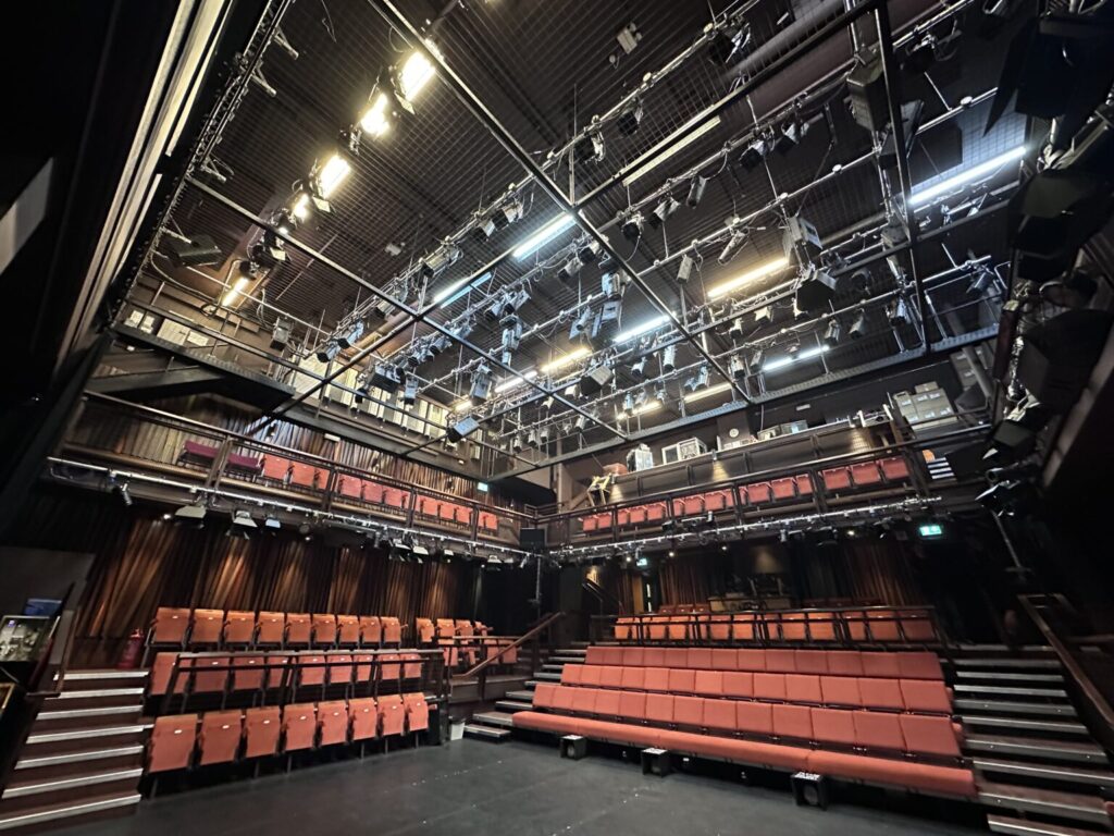 Lighting rig suspended above stage with empty audience seating