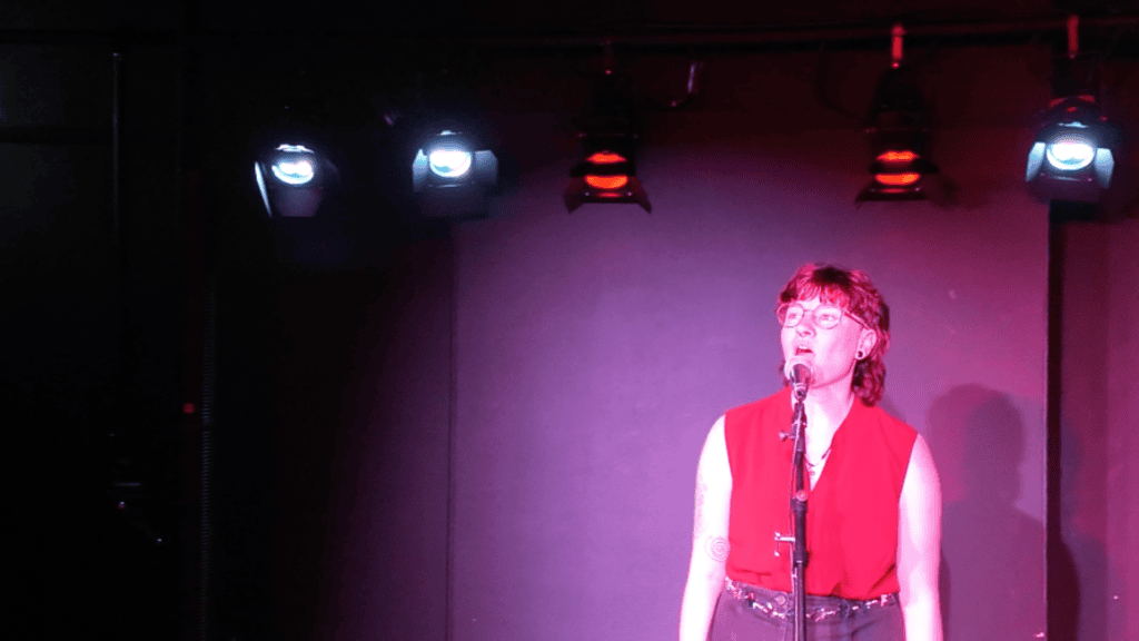 The Warren, Hull, young performer stands behind a microphone lit with ETC fixtures